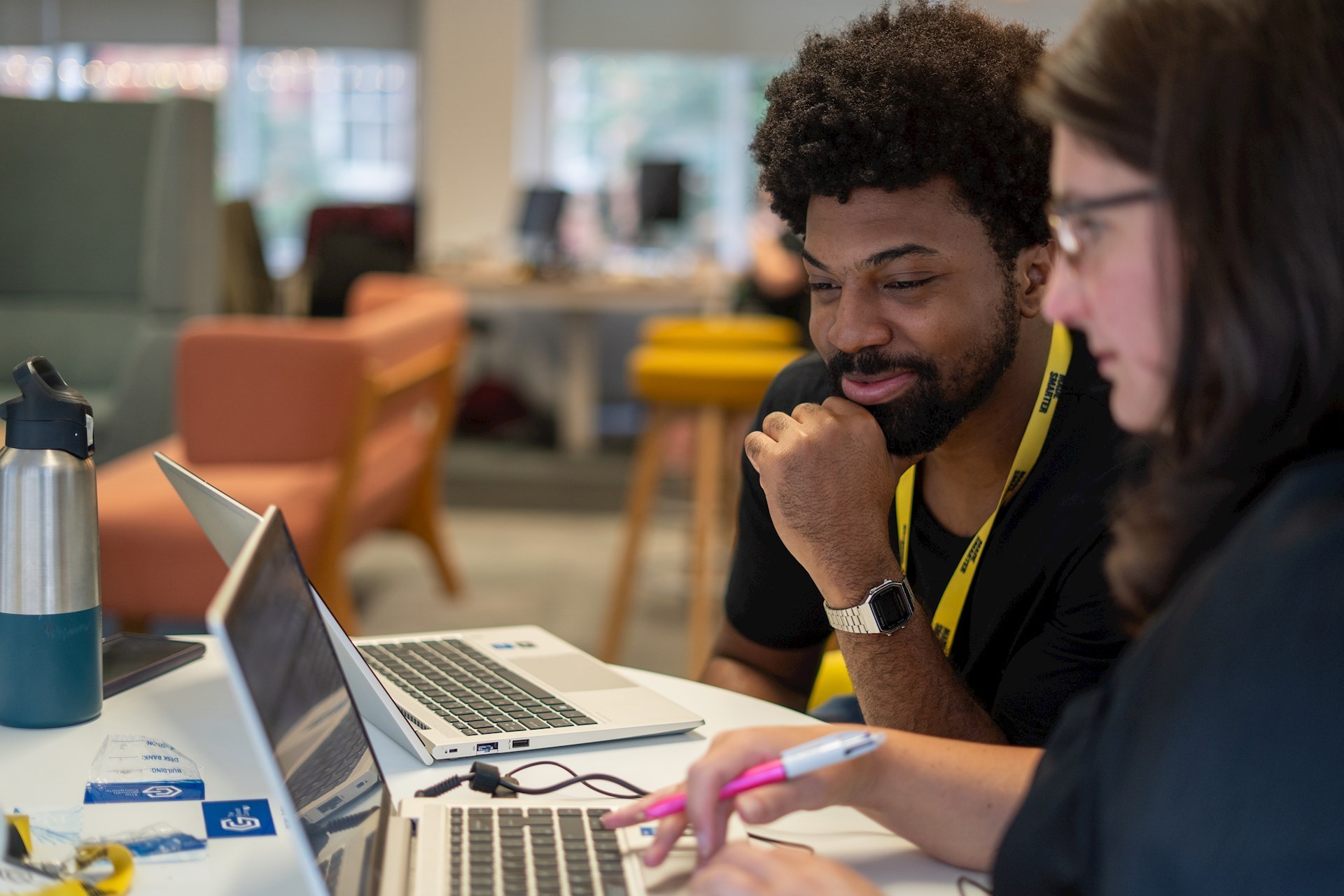 Two colleagues looking at a laptop together and smiling