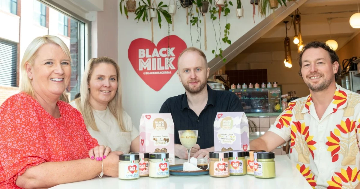 Founder and employees of Black Milk, a GC Business Finance client, sitting around a table with their products on