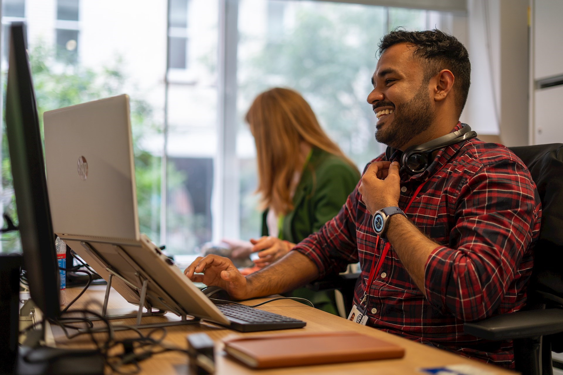 Colleague working on a laptop and smiling