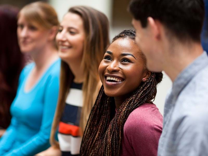 Image of people in conversation and smiling.