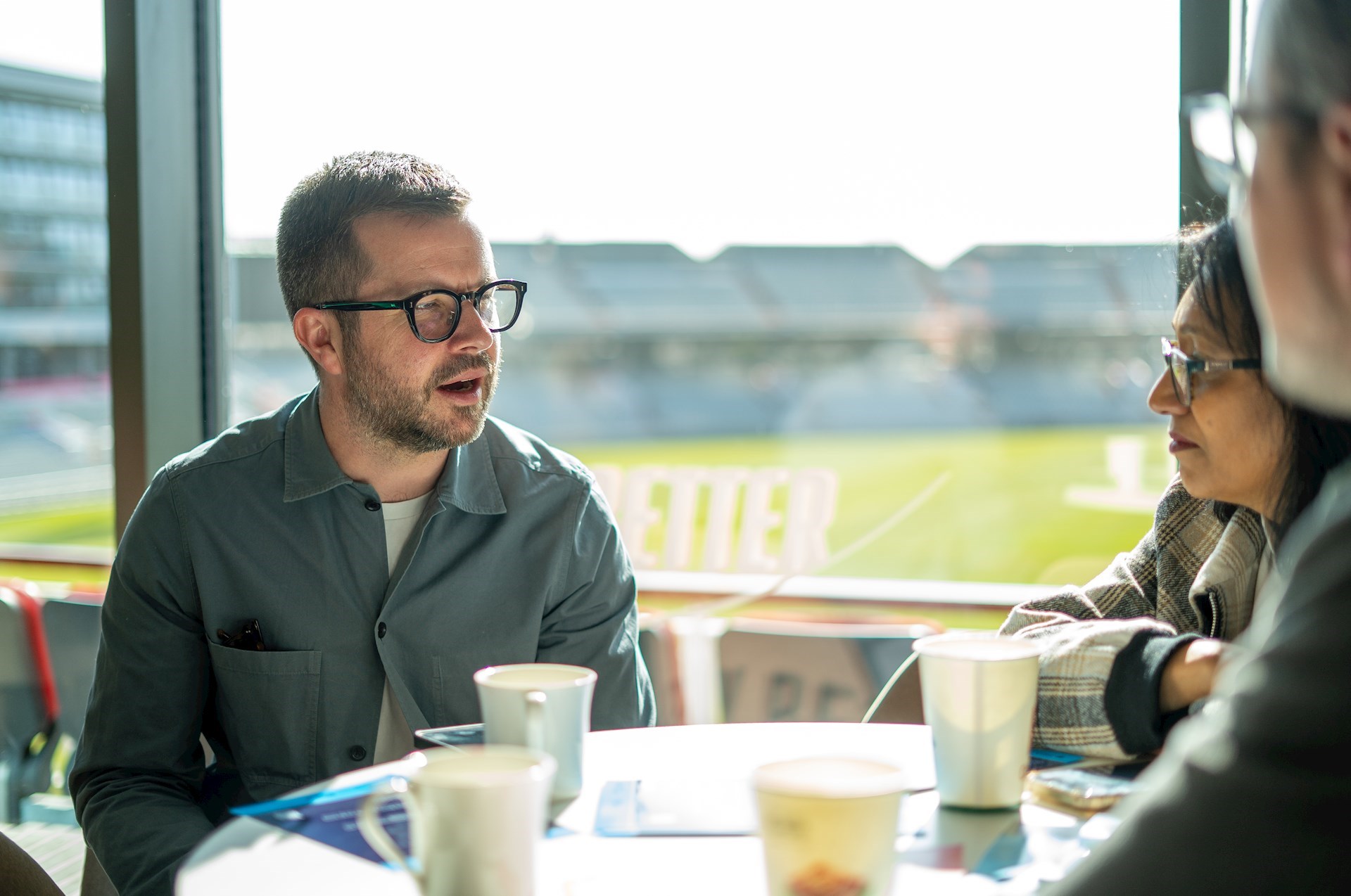 Three people sitting around a table having a conversation 