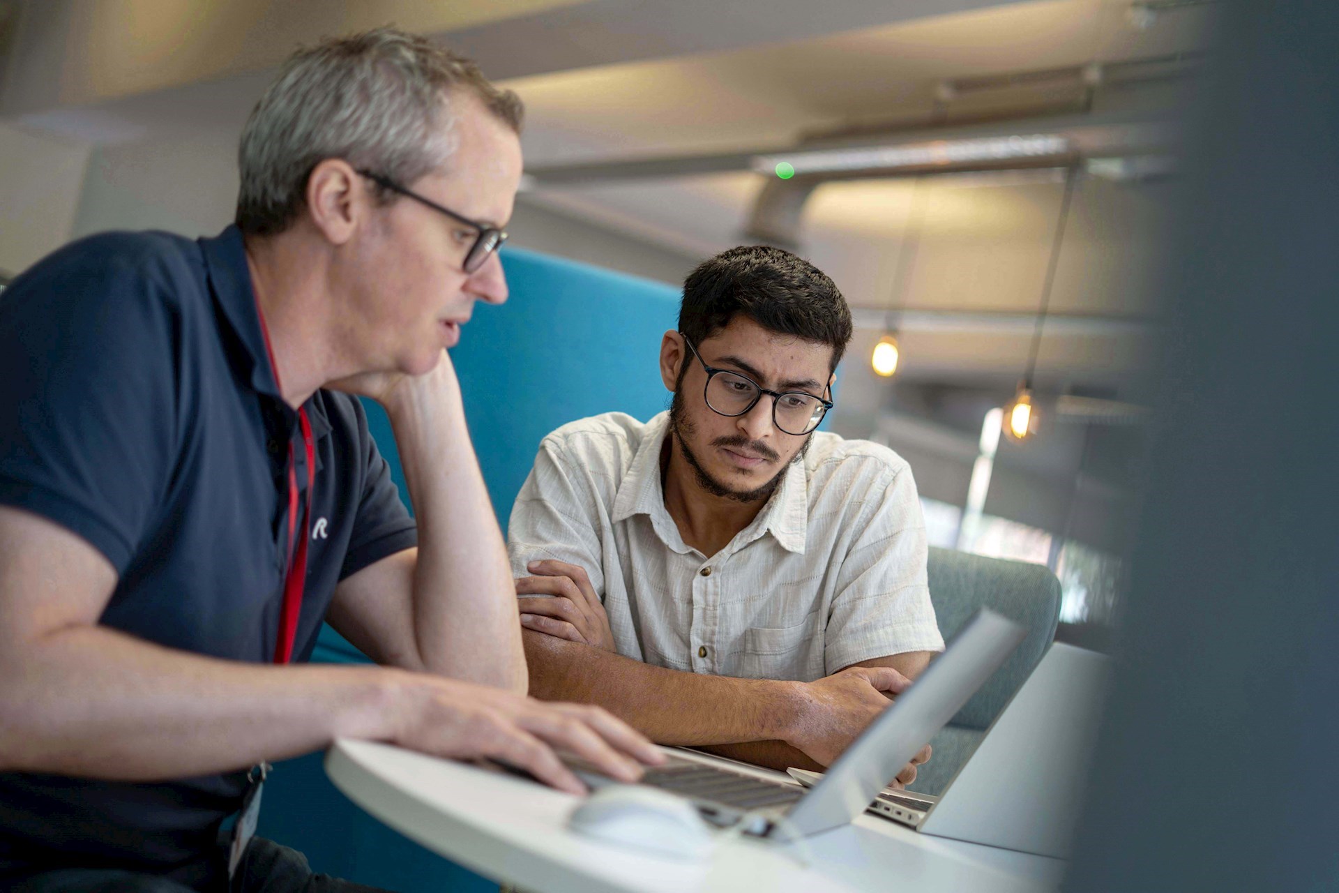 Two GC Insight colleagues looking at a laptop together