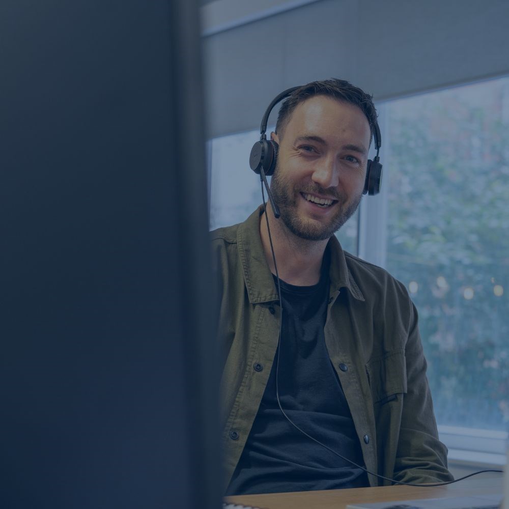 Colleague wearing a headset and smiling with a dark blue tint