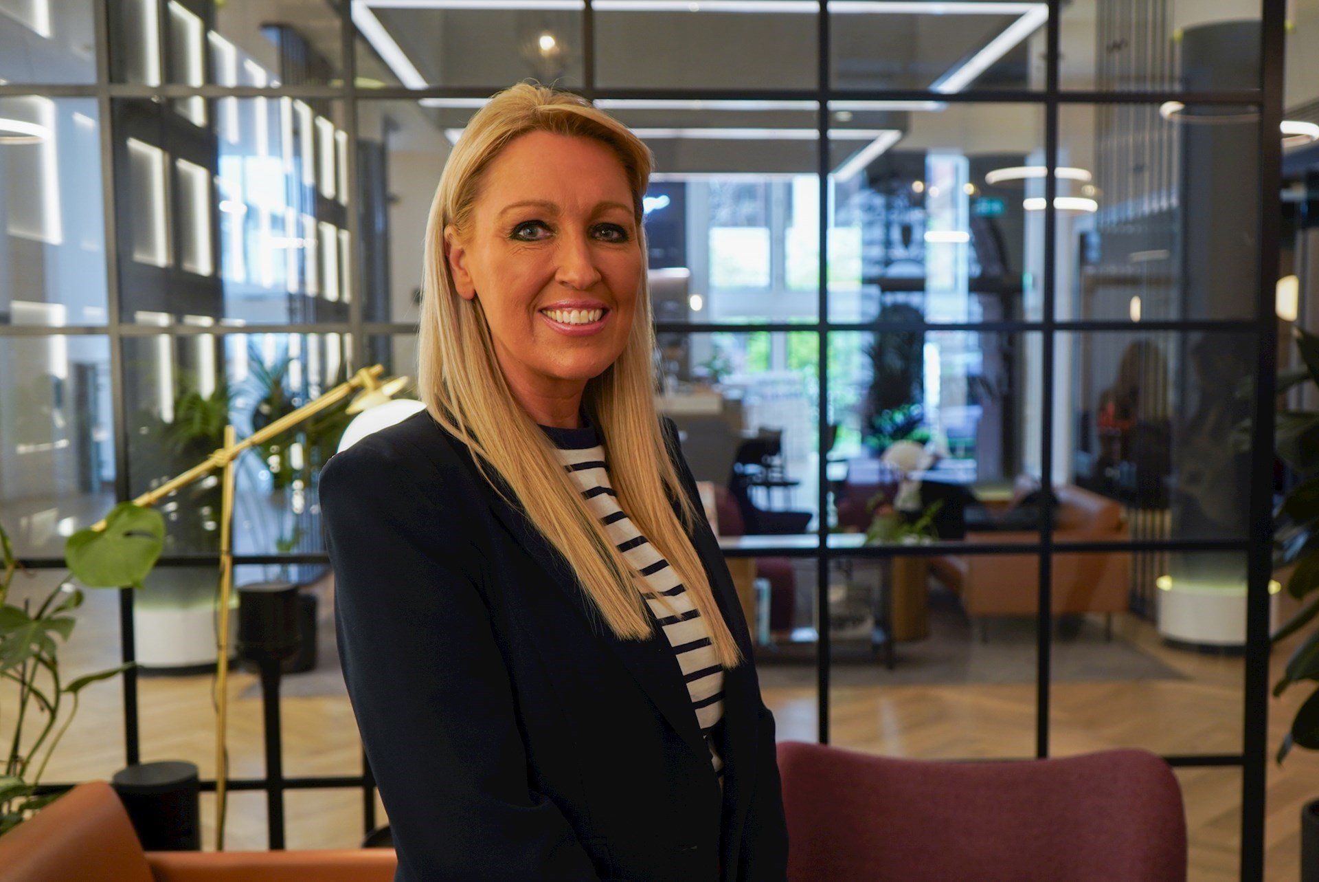 Janine Smith smiling with a modern office in the background